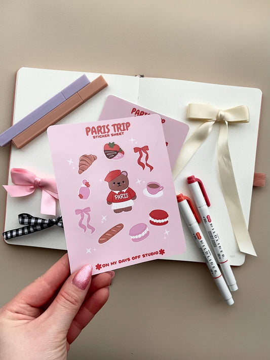 This stationery sticker sheet features a Paris Trip theme and has 10 colorful illustrations. This includes a bear in a Paris sweater, bows, chocolate dipped strawberries, croissant, perfume, macaroons and a french baguette. These glossy stickers are perfect for planners and bullet journals. 