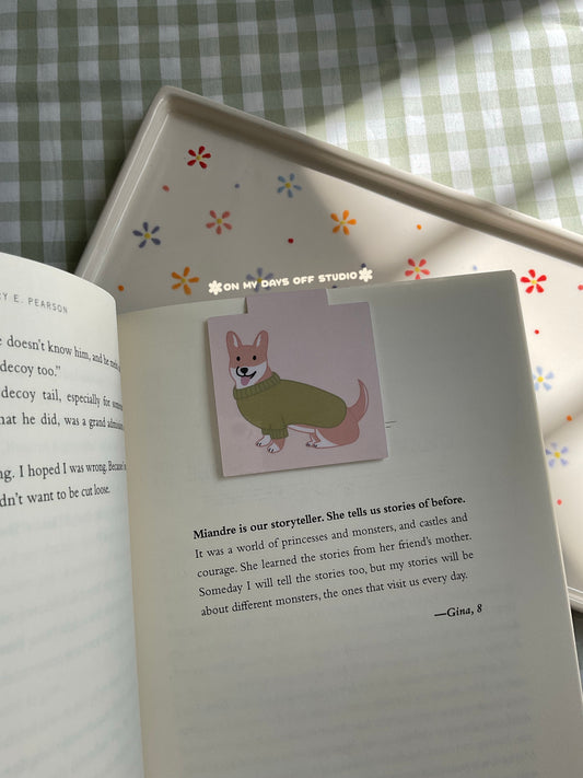 Magnetic Bookmark with a beige background and corgi wearing a green sweater