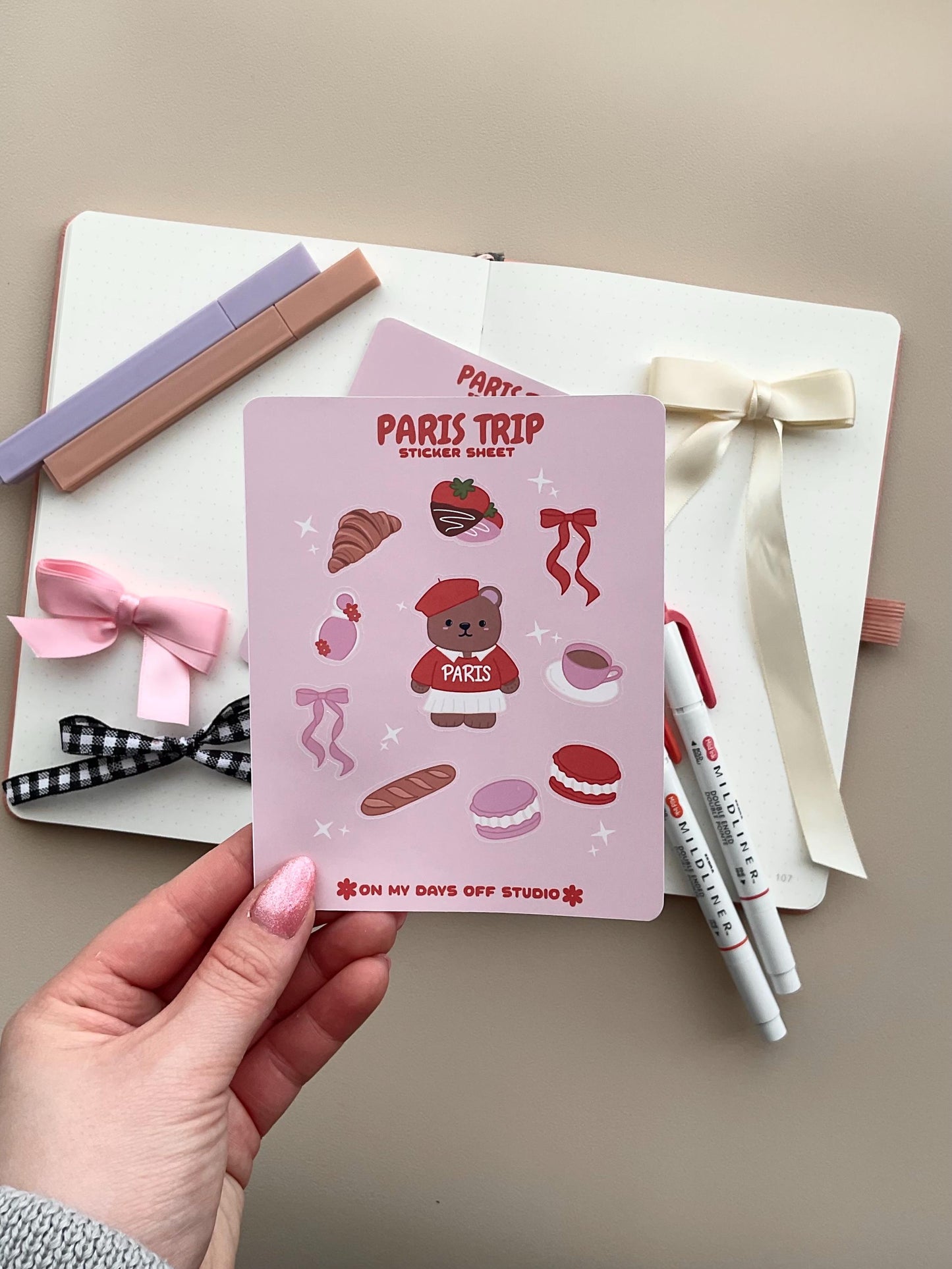 This stationery sticker sheet features a Paris Trip theme and has 10 colorful illustrations. This includes a bear in a Paris sweater, bows, chocolate dipped strawberries, croissant, perfume, macaroons and a french baguette. These glossy stickers are perfect for planners and bullet journals. 