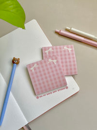 Pink girly themed sticky notes with two beige bows in the top corners