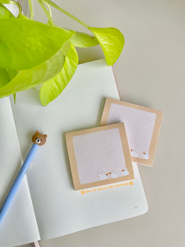 Cute yellow sticky notes with a grid background and 3 yellow ducks in the bottom right corner