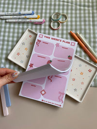 Weekly planner with a pink, red, bow and strawberry theme. It has sections for every day of the week and for notes.