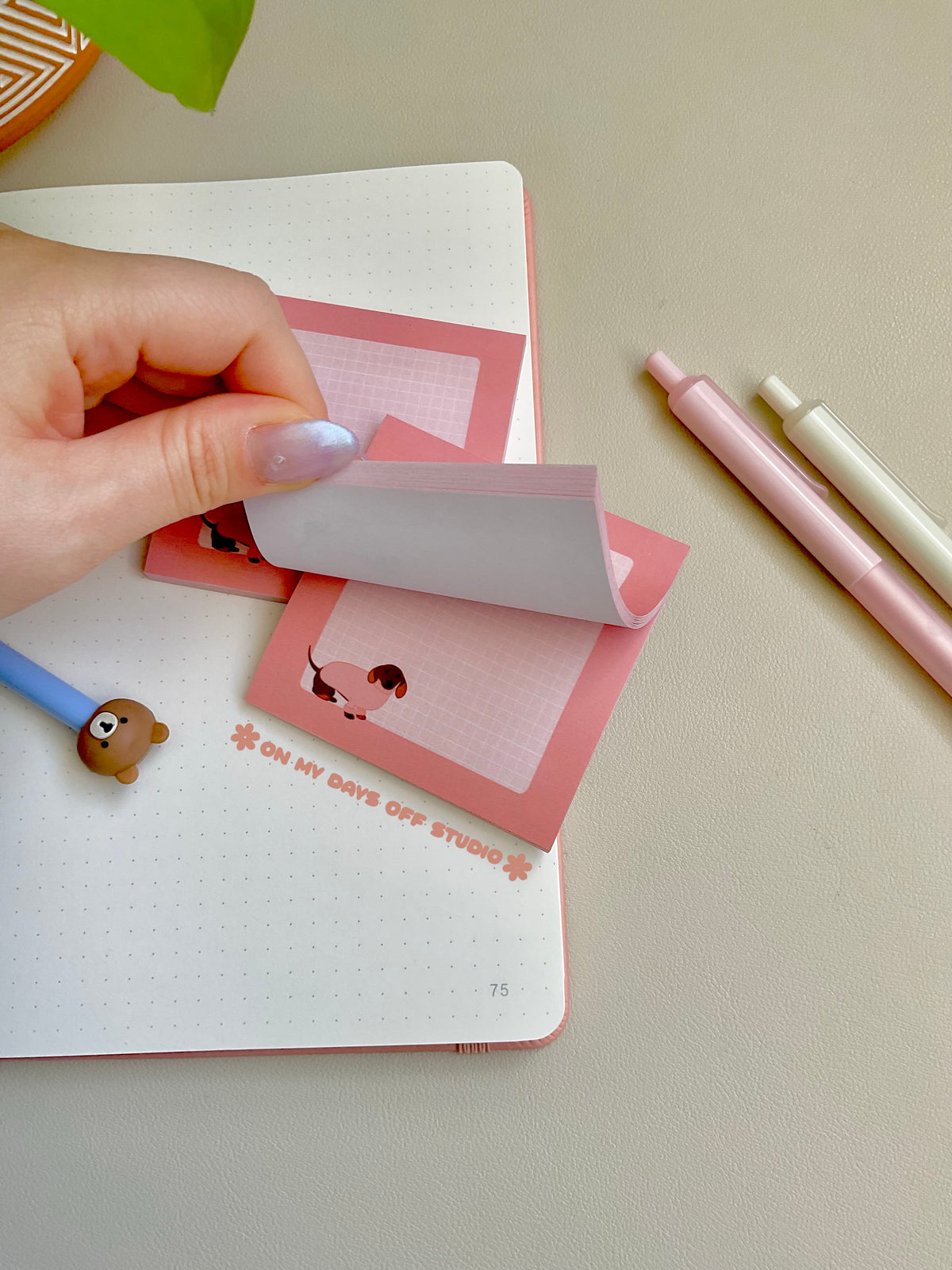 Cute pink sticky notes with a grid background and an adorable dachshund wearing a pink sweater in the bottom left corner