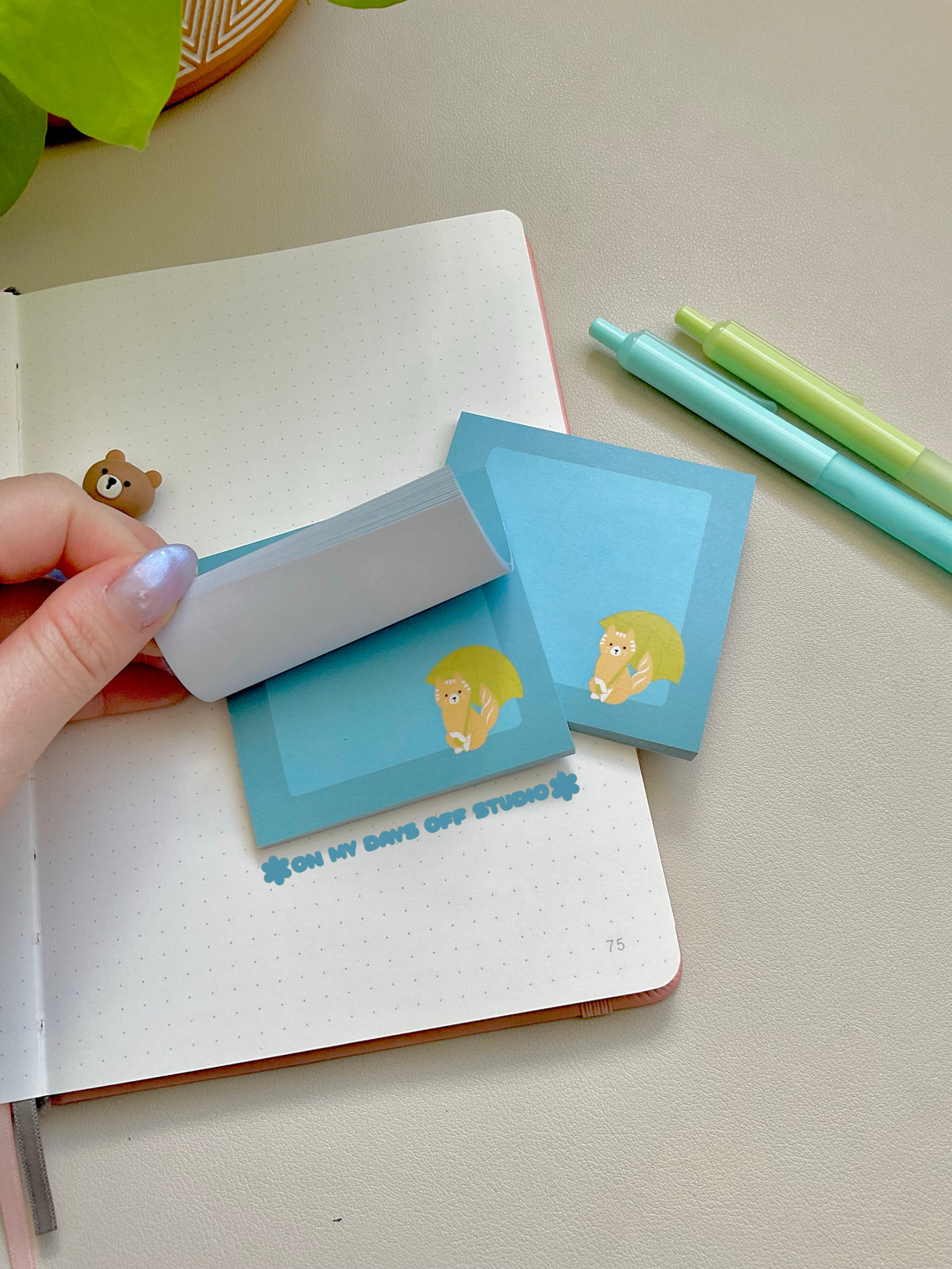 Blue sticky notes with a cat holding an umbrella in the bottom right corner