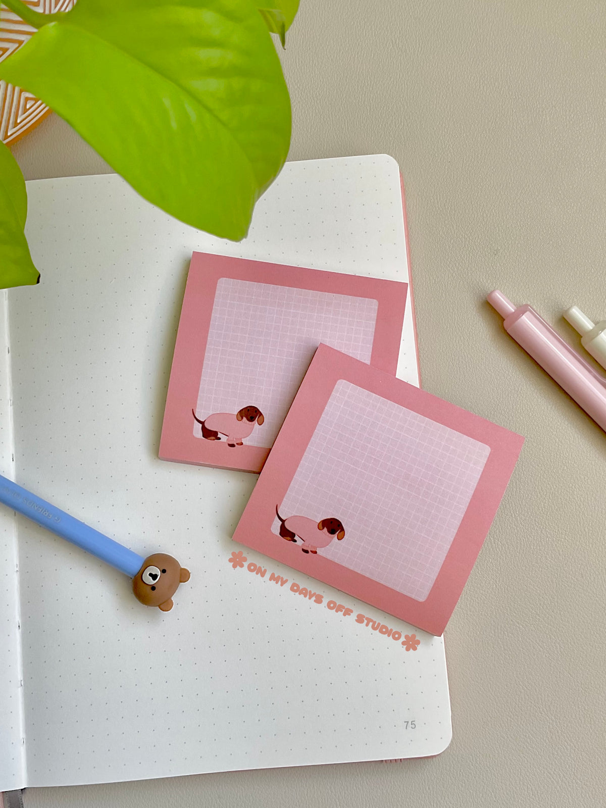 Cute pink sticky notes with a grid background and an adorable dachshund wearing a pink sweater in the bottom left corner