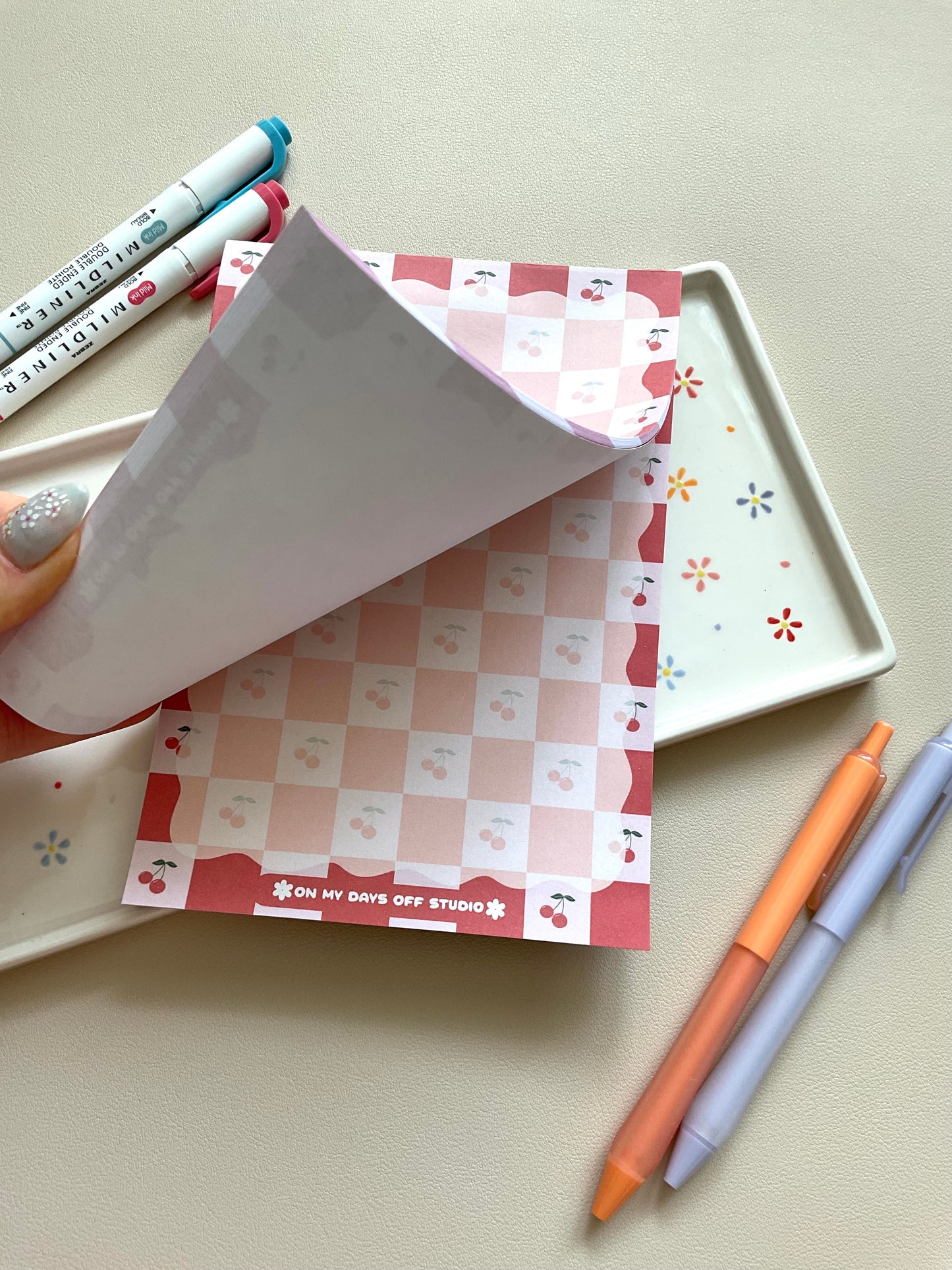 Red and pink checkered notepad with cute little cherries in the pink boxes of the print