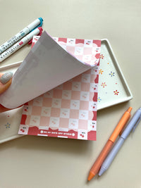 Red and pink checkered notepad with cute little cherries in the pink boxes of the print