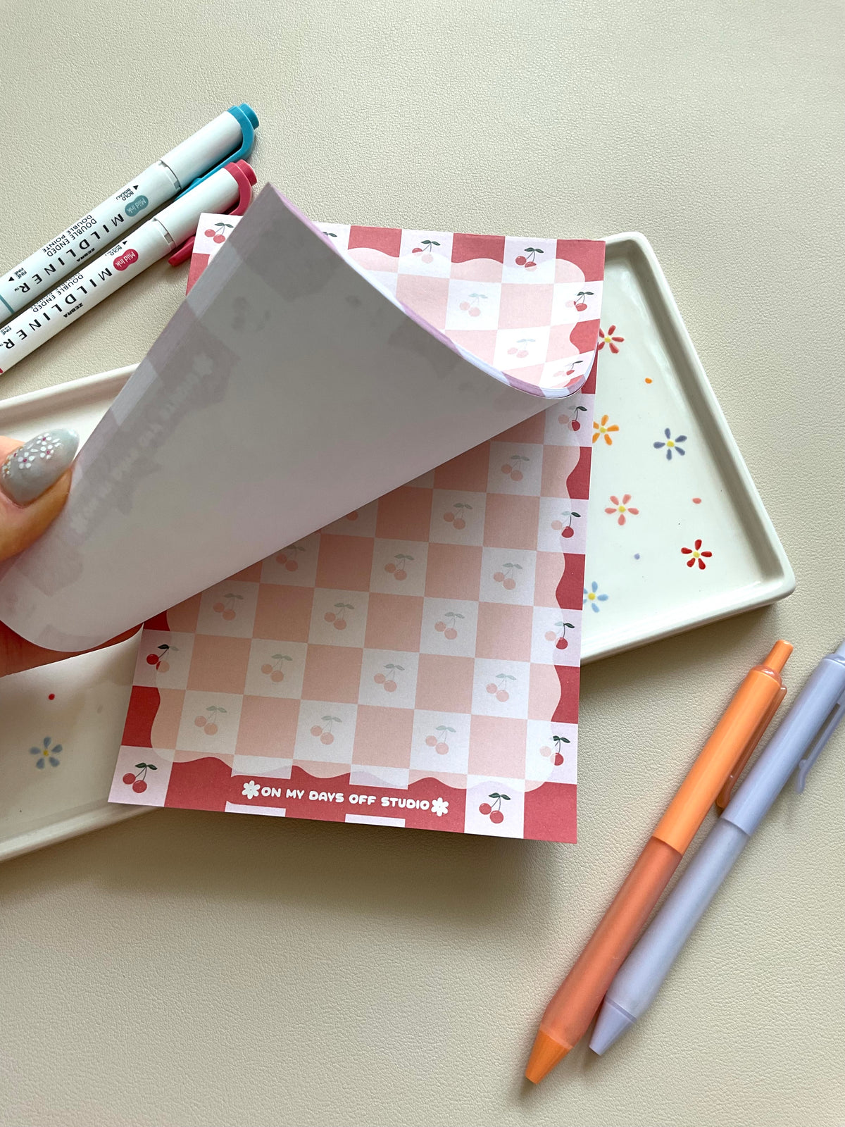Red and pink checkered notepad with cute little cherries in the pink boxes of the print