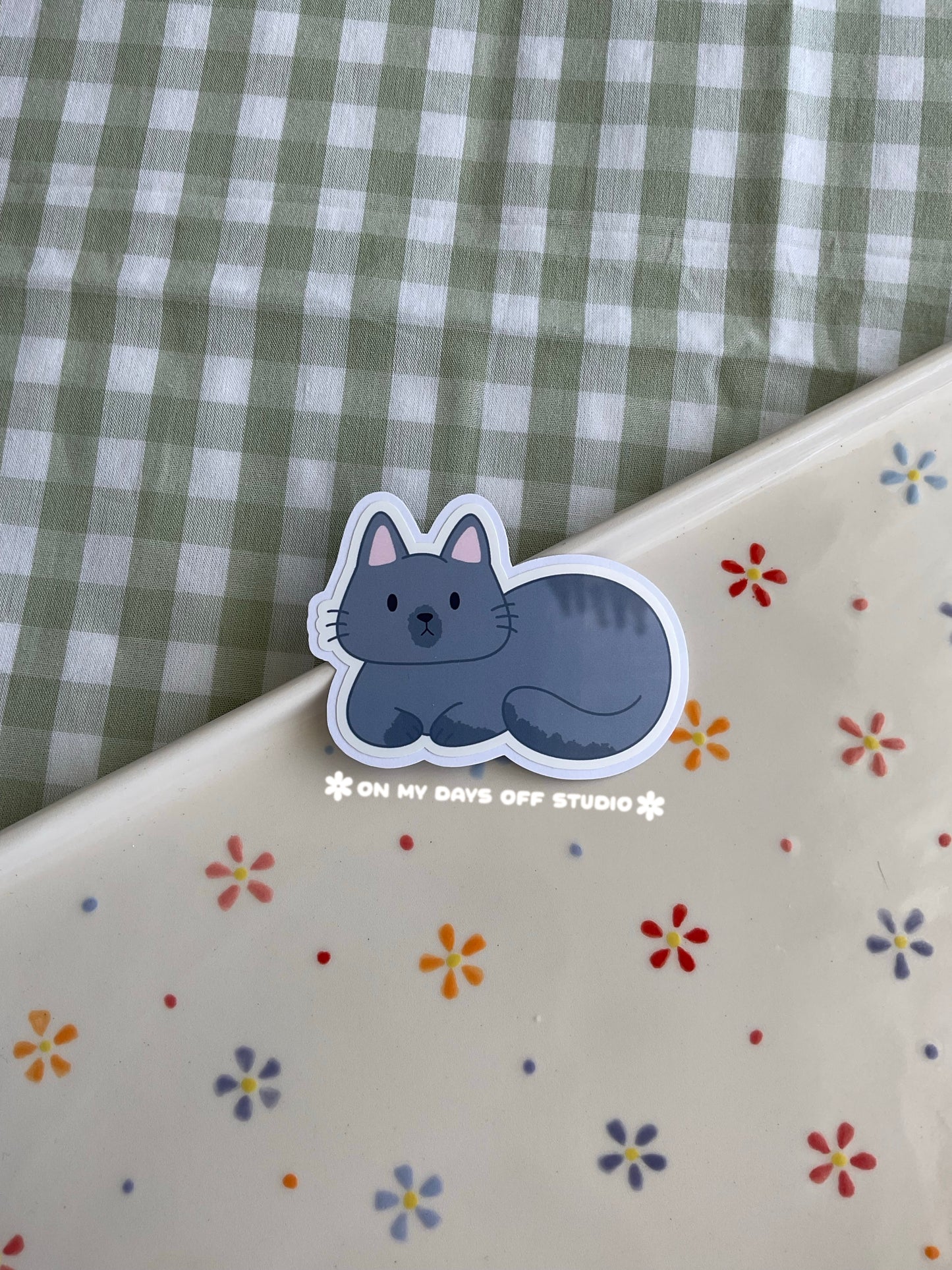 Cute vinyl sticker of a cute grey cat curled up 