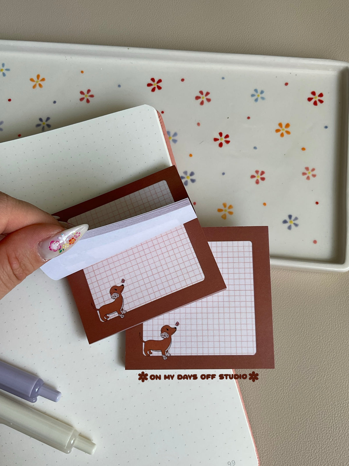Brown dachshund sticky notes with a grid background