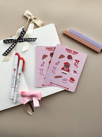 This stationery sticker sheet features a Paris Trip theme and has 10 colorful illustrations. This includes a bear in a Paris sweater, bows, chocolate dipped strawberries, croissant, perfume, macaroons and a french baguette. These glossy stickers are perfect for planners and bullet journals.&nbsp;