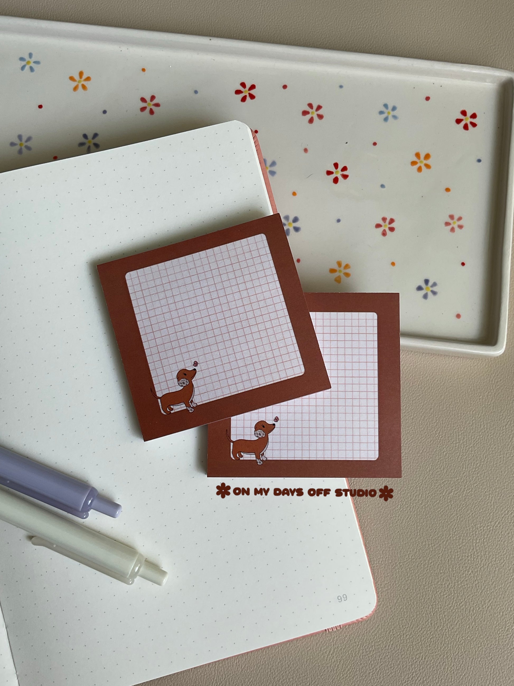 Brown dachshund sticky notes with a grid background