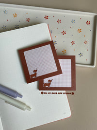Brown dachshund sticky notes with a grid background