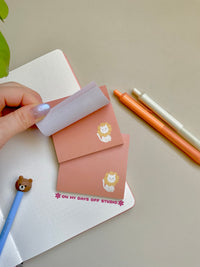 peach colored sticky notes with a white cat in the right corner wearing flower petals around it's head