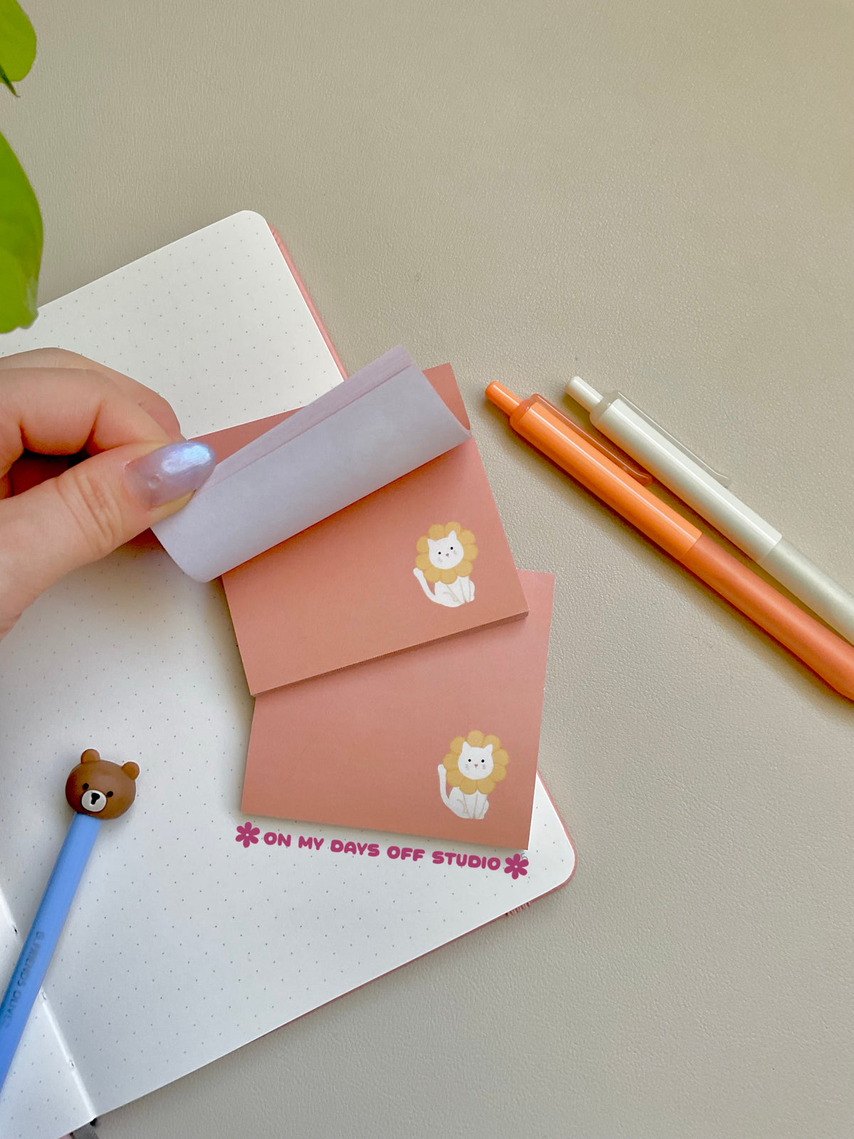 peach colored sticky notes with a white cat in the right corner wearing flower petals around it's head