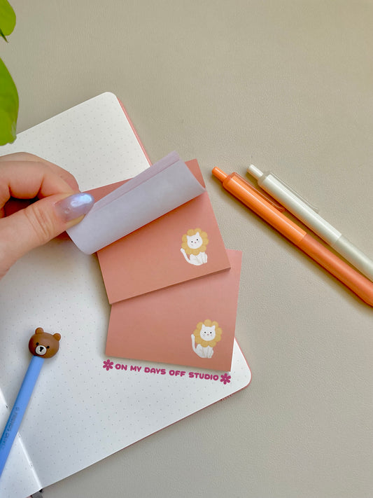 peach colored sticky notes with a white cat in the right corner wearing flower petals around it's head