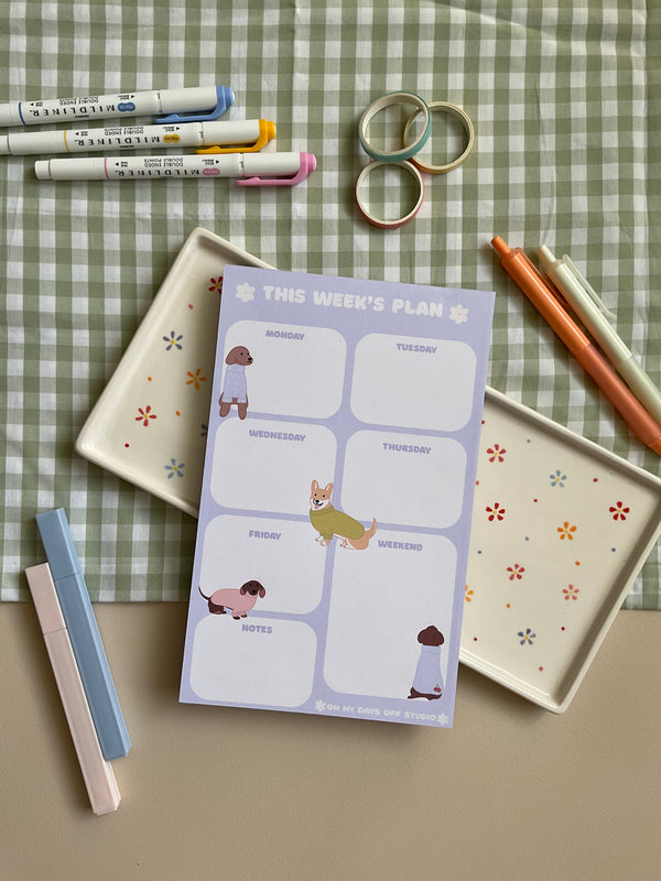 Weekly planner with a purple and dog theme. It has sections for every day of the week and for notes.