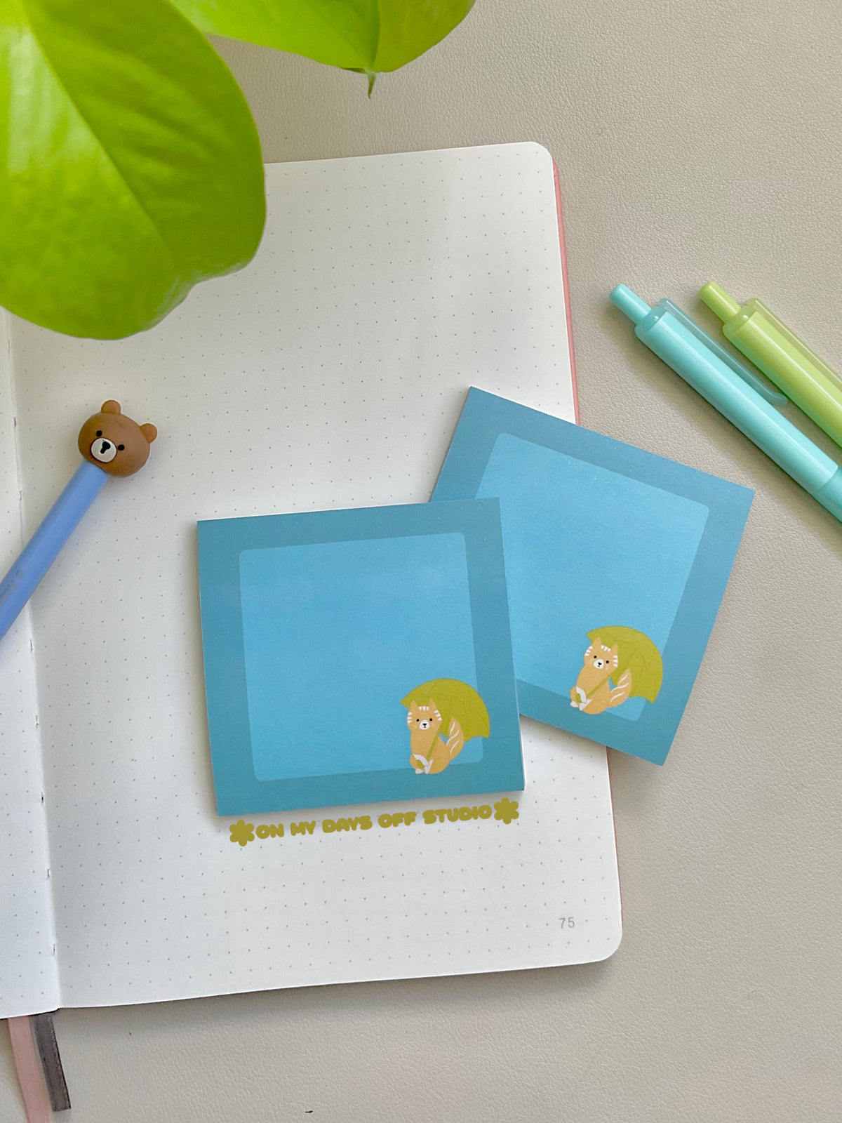 Blue sticky notes with a cat holding an umbrella in the bottom right corner