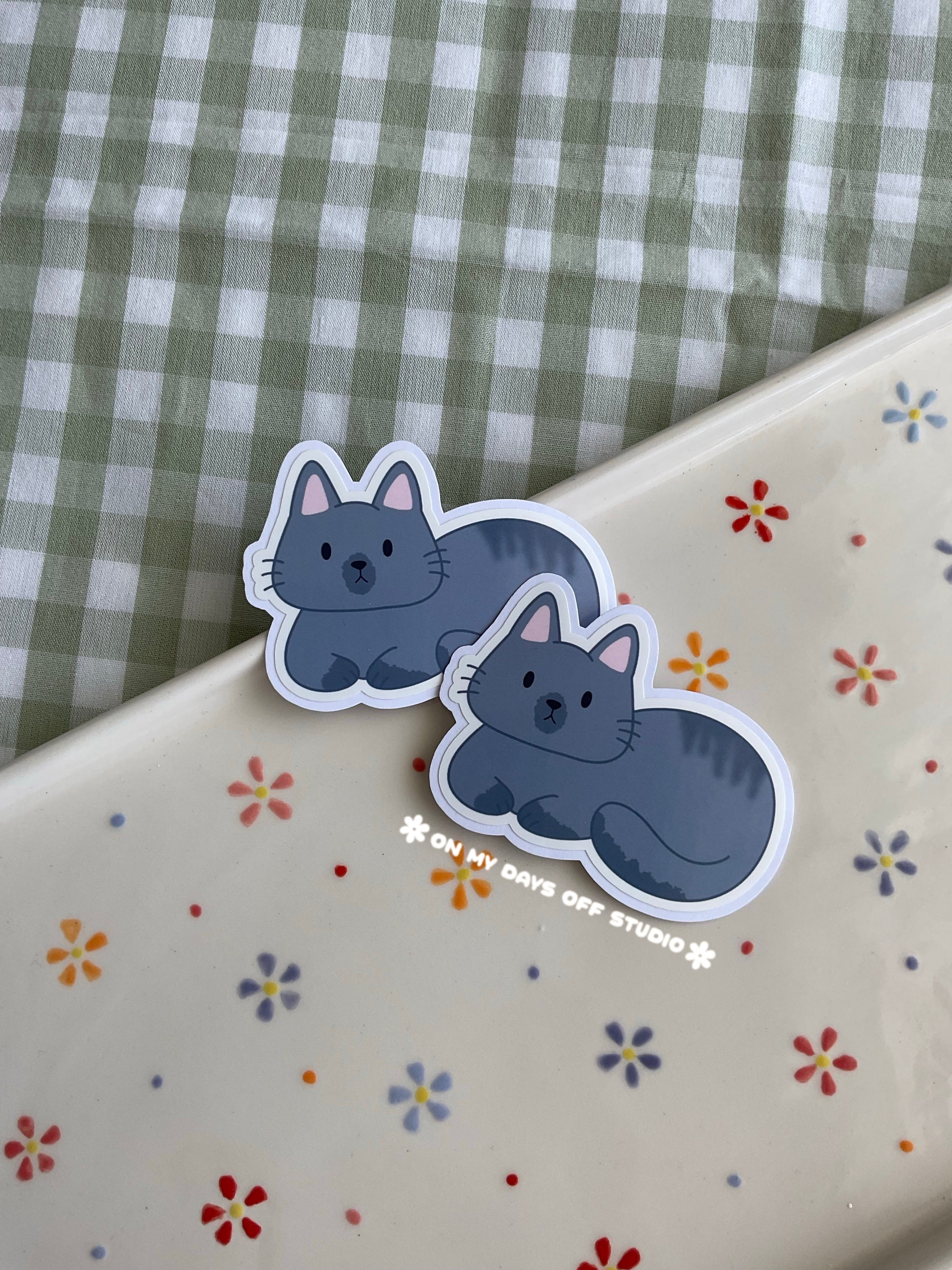 Cute vinyl sticker of a cute grey cat curled up 