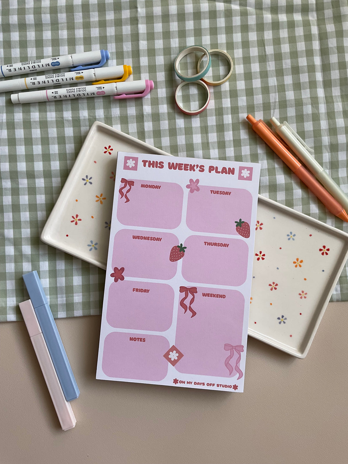 Weekly planner with a pink, red, bow and strawberry theme. It has sections for every day of the week and for notes.
