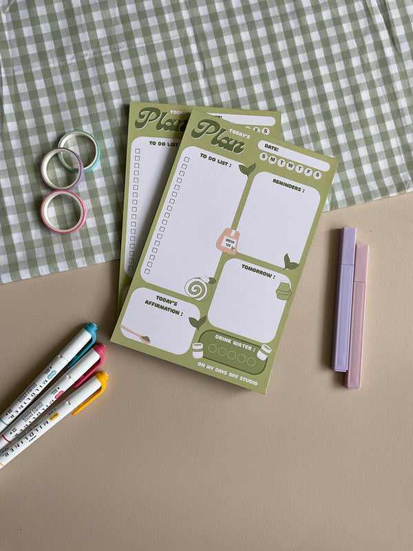 A daily planner notepad with a matcha theme, featuring illustrations of matcha drinks and leaves. It has sections for a t do list, reminders, tomorrow list, today's affirmation and water in take tracker.