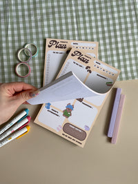 A daily planner notepad with a coffee theme. Features a place for your to do list. reminders, list for tomorrow, today's affirmation and a water intake tracker