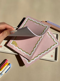 Cute light pink notepad with a retro wavy boarder in white and green. A cute corgi in a green sweater sitting in the bottom left corner