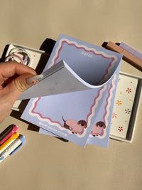 Cute light purple notepad with a retro wavy boarder in white and pink. A cute dachshund in a pink sweater sitting in the bottom right corner
